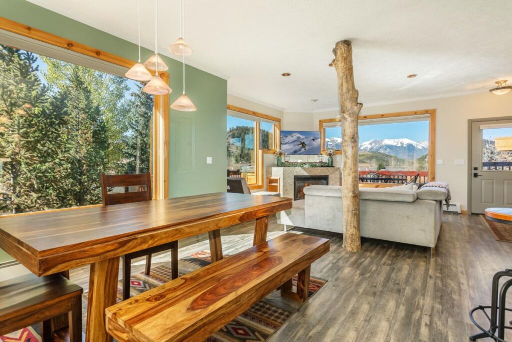 Lake Ridge Luxe dining area with a live-edge table and benches by the windows in Dillon, Colorado
