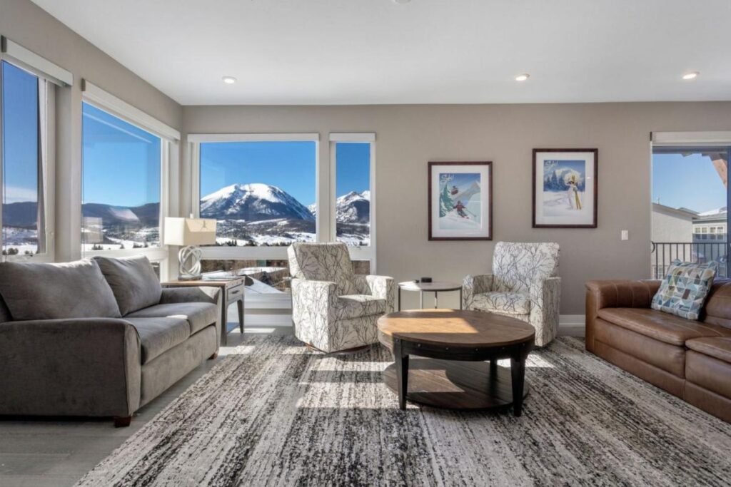Penthouse Retreat living room with armchairs and picture windows onto snow-capped peaks in Dillon, Colorado
