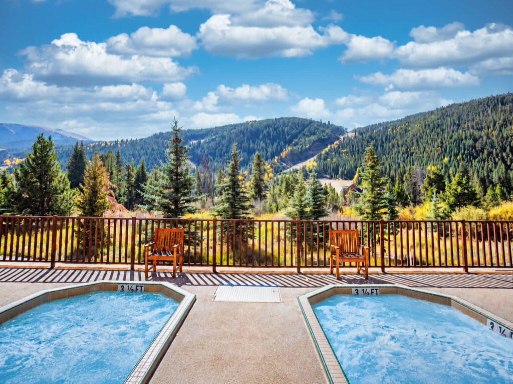 Slopeside's deck with two hot tubs and chairs facing the mountains in Keystone, Colorado