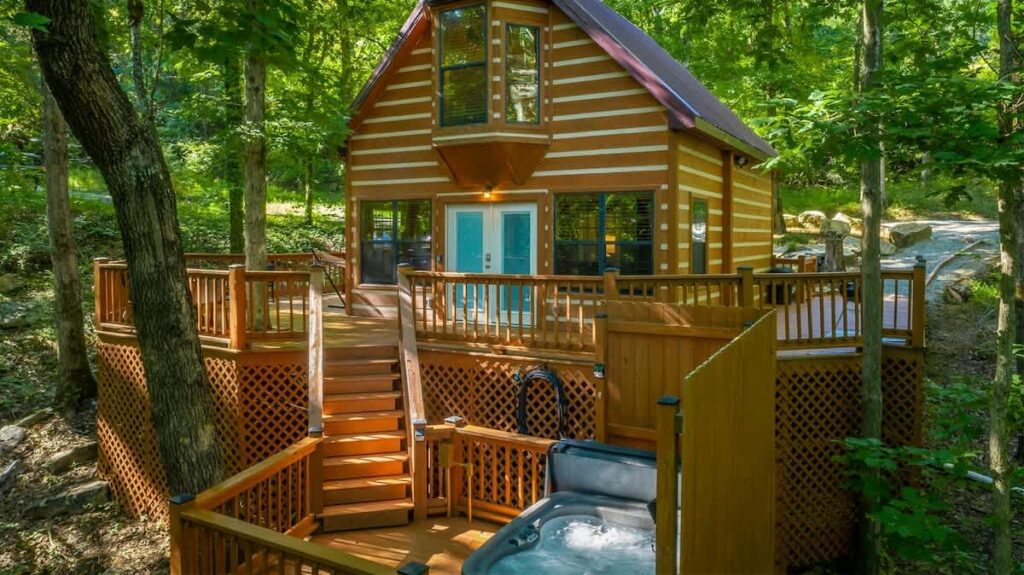 Grady's Hideaway, a small log cabin with a raised deck and a hot tub below in the woods of Trenton, Georgia