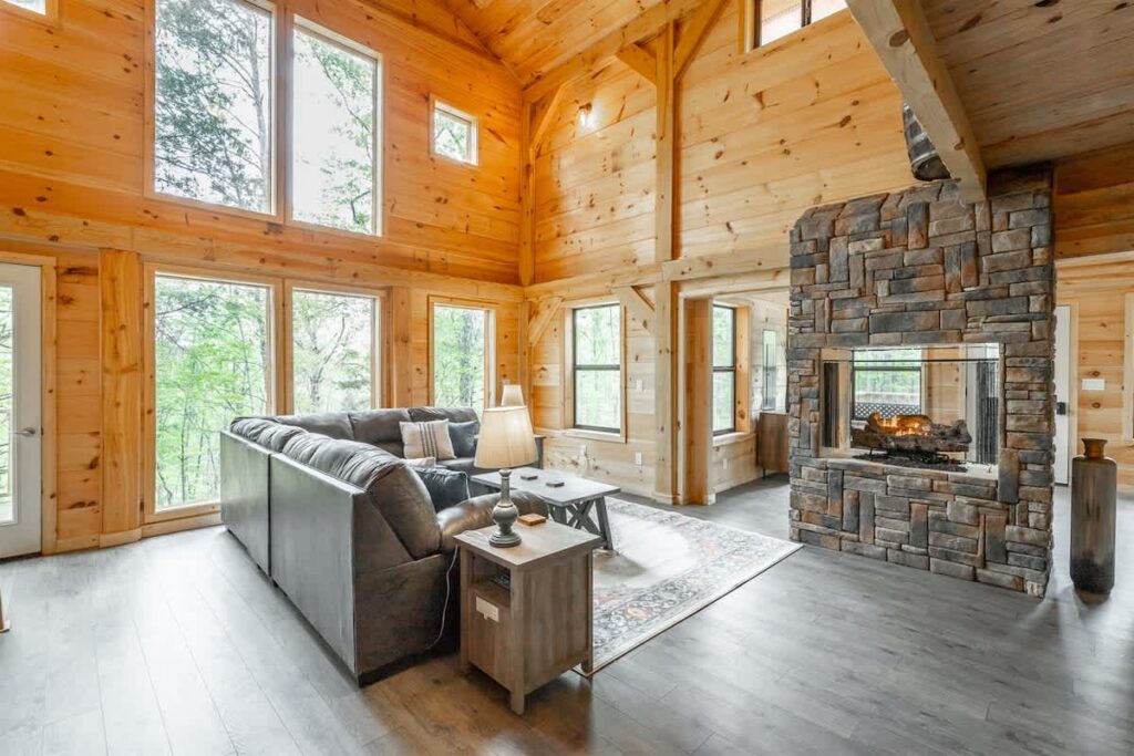 Timber Creek Lodge living room with tall windows and a stone fireplace in Trenton, Georgia