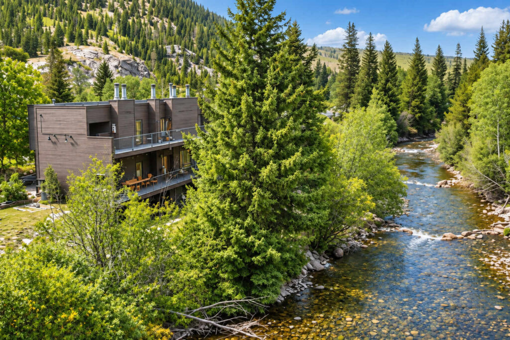 The Creekside Retreat, a dark-timber condo building beside a mountain creek in Frisco, Colorado
