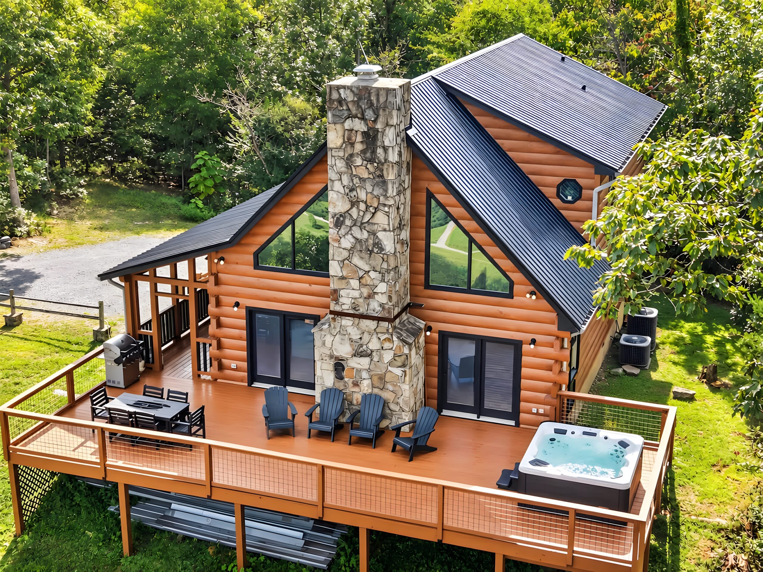 Crossbow Cabin from above, a log cabin with a stone chimney, a wide deck and a hot tub in the woods of Rising Fawn, Georgia