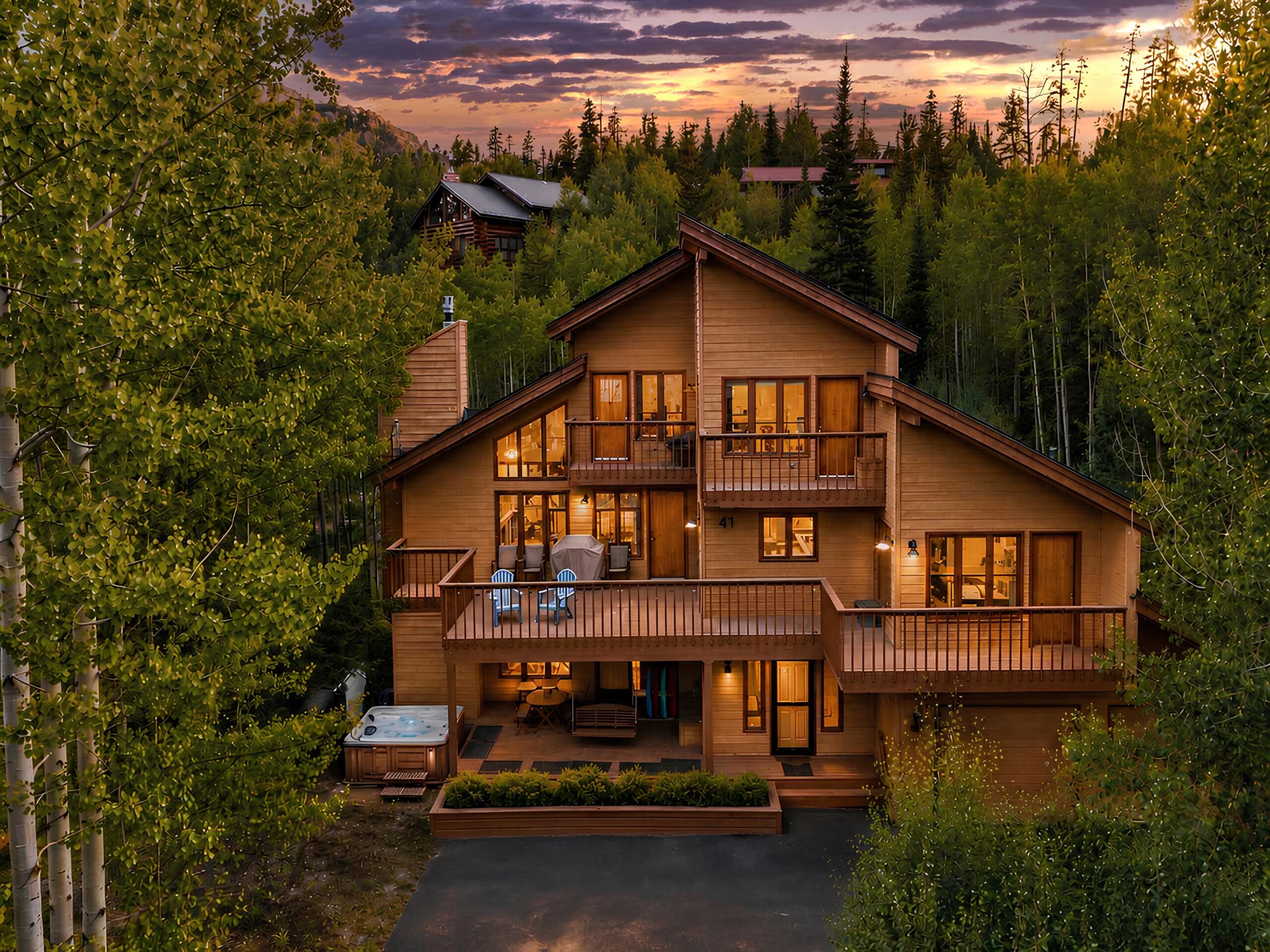Red Bird Retreat, a Home Base cabin with three decks and a hot tub among the aspens at dusk in Silverthorne, Colorado